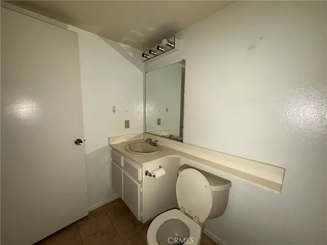 a spacious bathroom with a granite countertop sink a toilet and a mirror