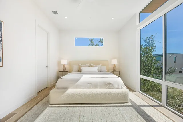 a bedroom with a bed and a large window