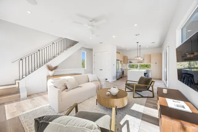 a living room with furniture kitchen view and a flat screen tv
