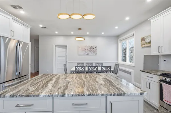 a kitchen with kitchen island granite countertop a stove cabinets and refrigerator