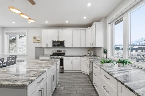 a kitchen with stainless steel appliances granite countertop a stove a sink and a refrigerator