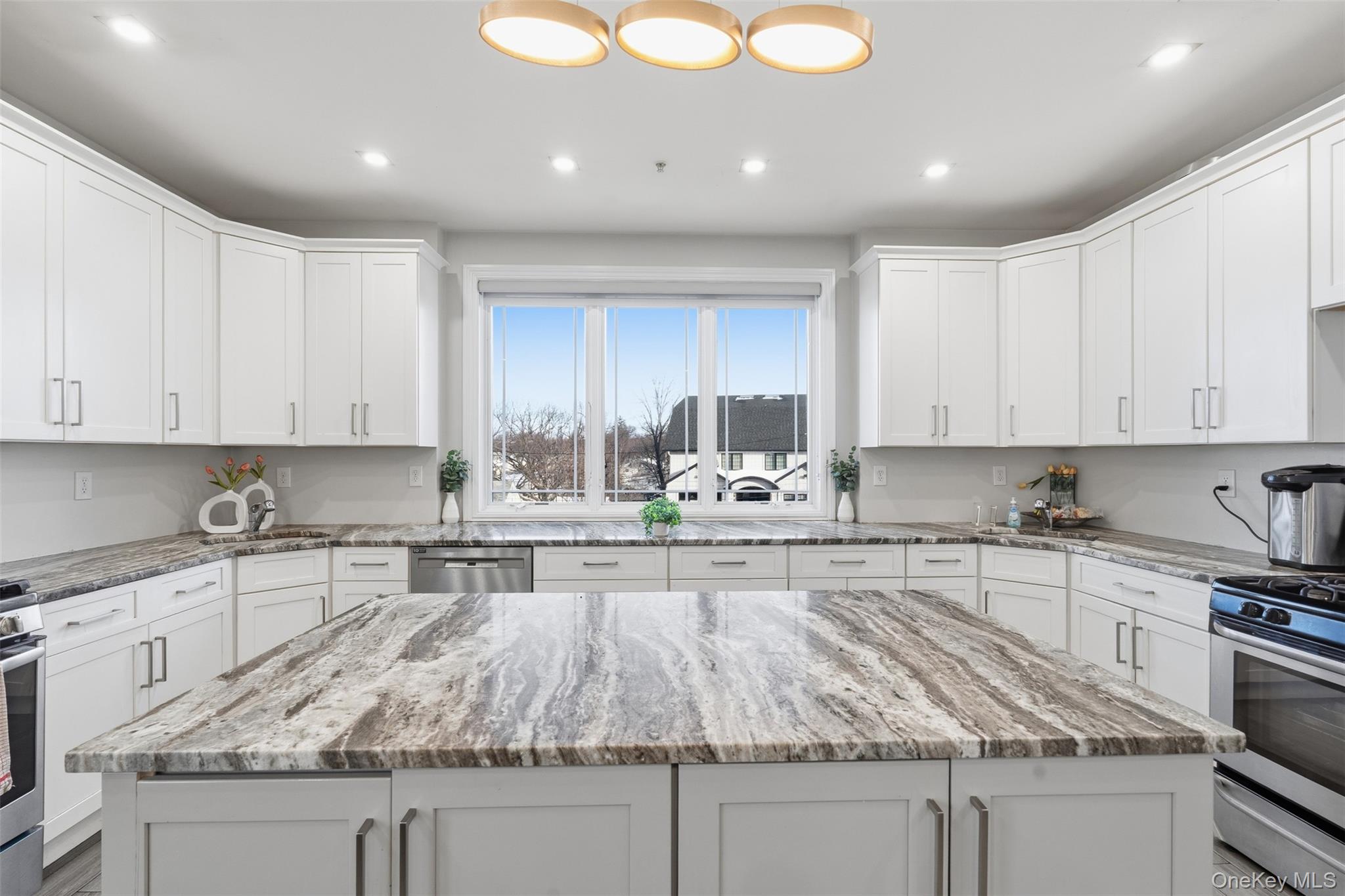 7 Park Street, Unit 301 Spring Valley, NY 10977 - Photo 9 of 33 a kitchen with kitchen island granite countertop a sink a stove and cabinets