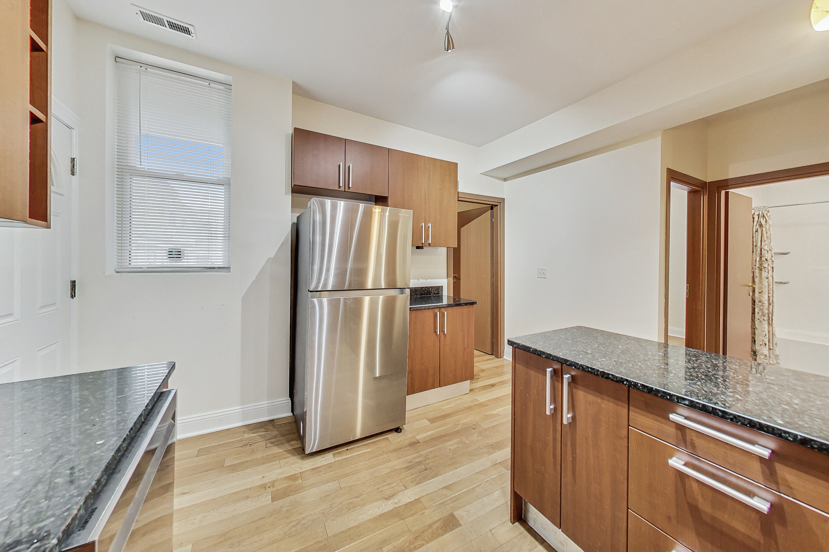 7321 North Paulina Street, Unit 2 Chicago, IL 60626 - Photo 11 of 27 a kitchen with granite countertop a refrigerator and a sink