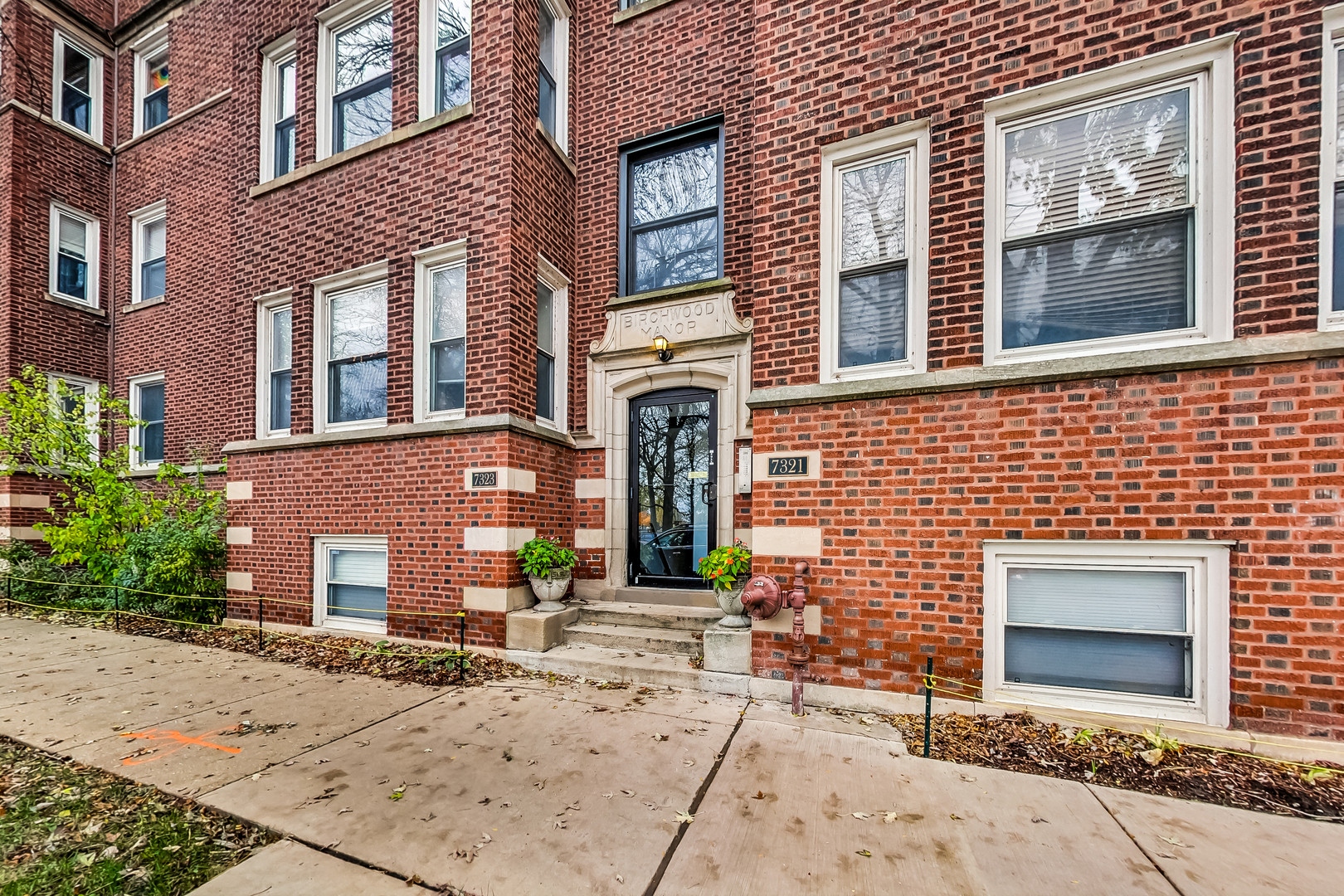 7321 North Paulina Street, Unit 2 Chicago, IL 60626 - Photo 2 of 27 front view of a brick house with a small yard