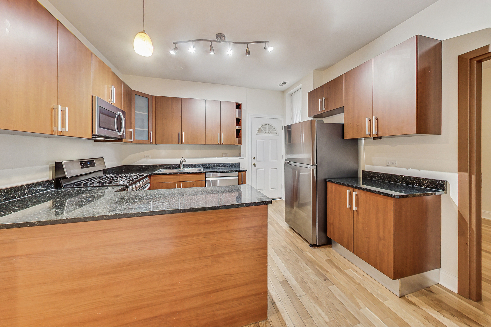 7321 North Paulina Street, Unit 2 Chicago, IL 60626 - Photo 8 of 27 a kitchen with stainless steel appliances granite countertop a refrigerator a sink dishwasher a stove and a oven with wooden floor