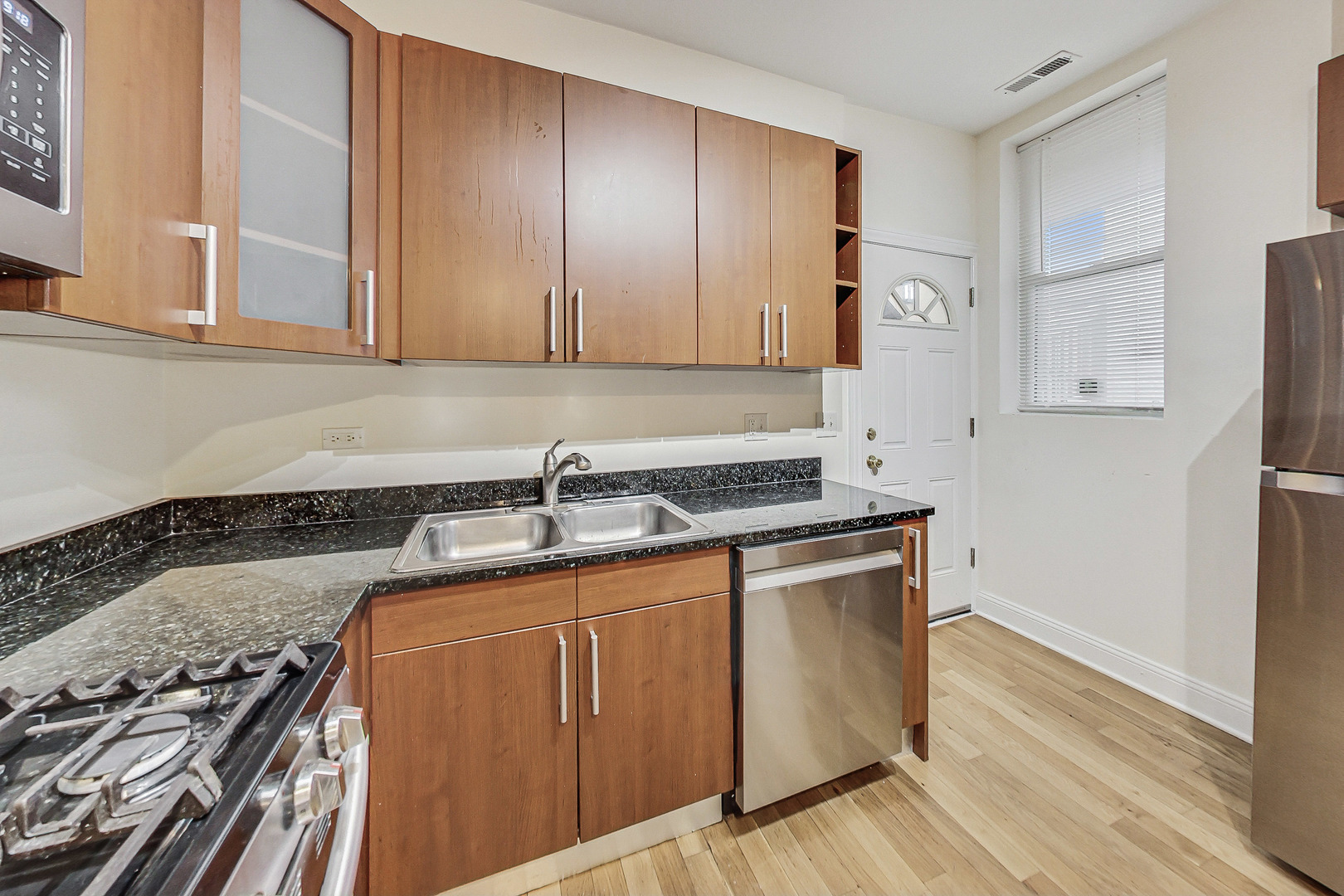 7321 North Paulina Street, Unit 2 Chicago, IL 60626 - Photo 10 of 27 a kitchen with wooden cabinets and a stove top oven