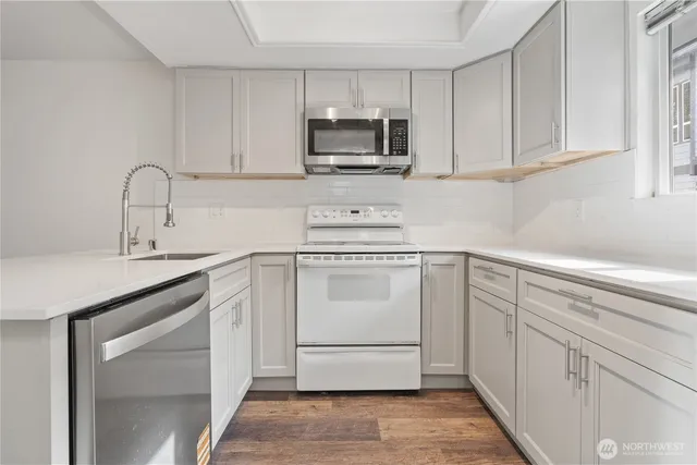 a kitchen with white cabinets and white appliances