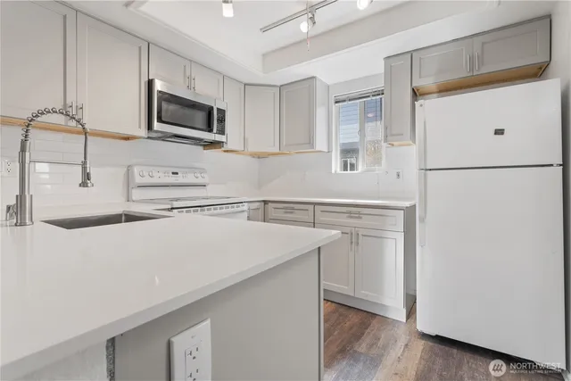 a kitchen with appliances a sink and cabinets