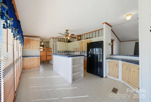 a view of a kitchen with refrigerator and wooden floor