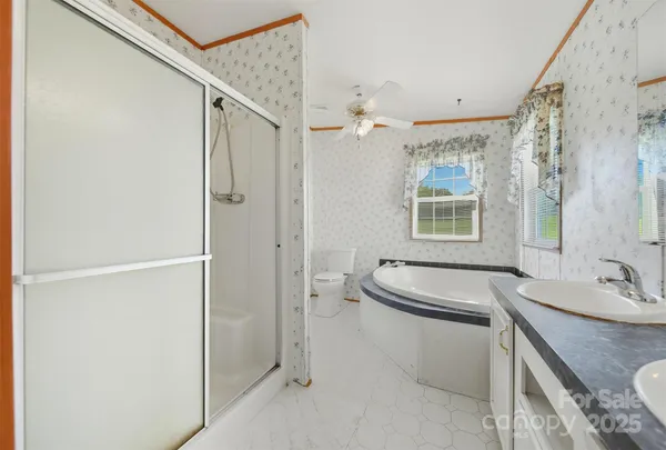 a bathroom with a granite countertop sink a toilet and shower