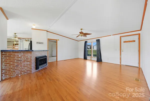 a view of empty room with wooden floor and fireplace