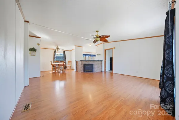 a view of a livingroom with wooden floor and a ceiling fan