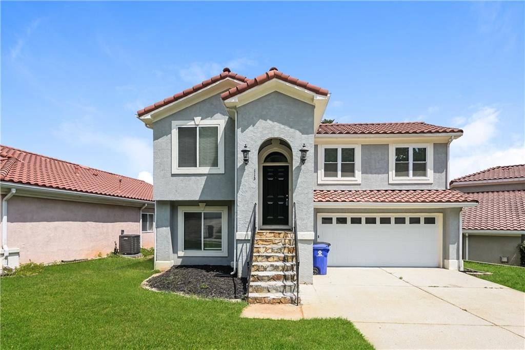 a front view of a house with a garden and plants