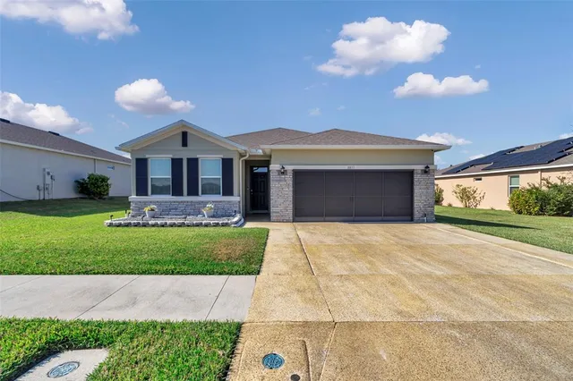 a front view of a house with a yard and garage