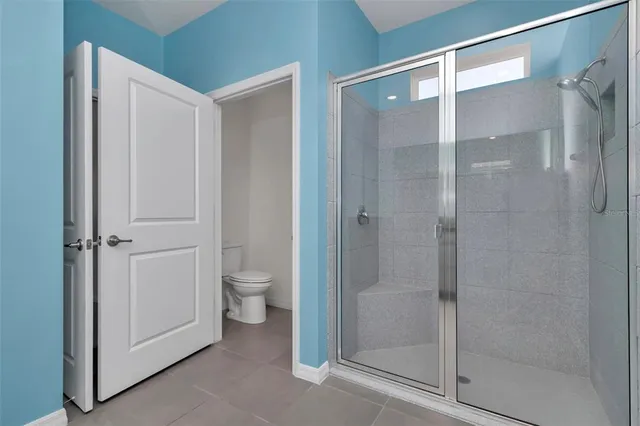 an empty room with closet and a chandelier fan