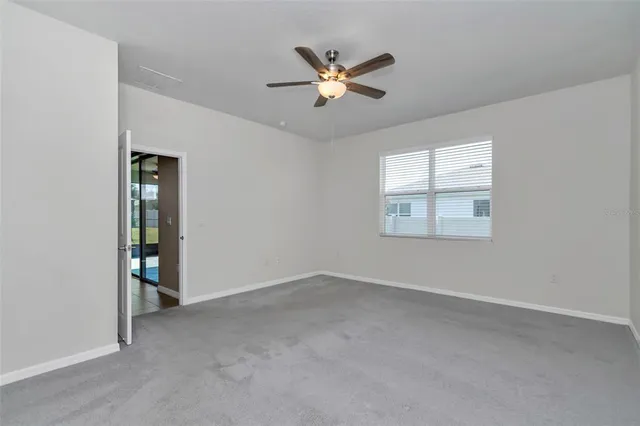 a view of a livingroom with a piano and a ceiling fan