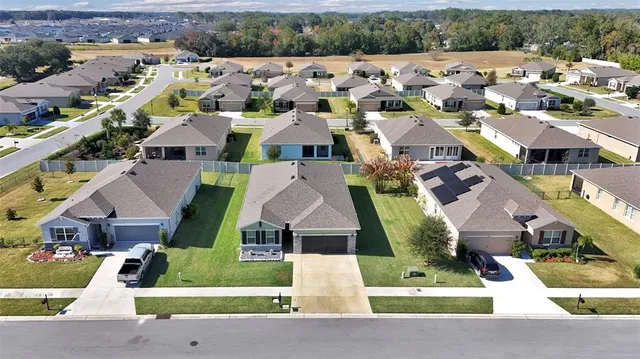 an aerial view of multiple houses with a yard