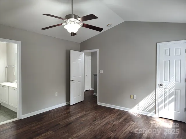 an empty room with wooden floor chandelier and entryway
