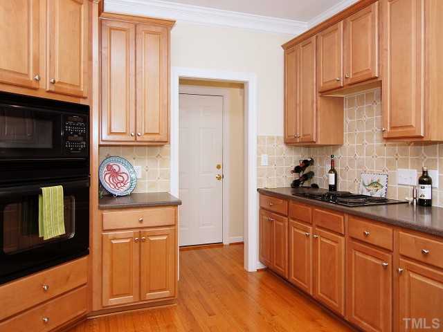 8604 Wapello Lane Raleigh, NC 27613 - Photo 11 of 25 Lots of storage behind raised-panel cabinet doors and substantial pantry closet.