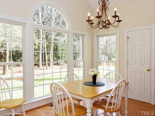 8604 Wapello Lane Raleigh, NC 27613 - Photo 13 of 25 Breakfast bar opens to morning room with floor-to-ceiling windows and single French door to deck.