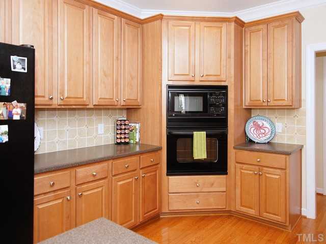 8604 Wapello Lane Raleigh, NC 27613 - Photo 10 of 25 Cook's kitchen with attractive tiled backsplash, plenty of recessed lighting and miles of solid-surface countertop space plus convenient integrated sink.