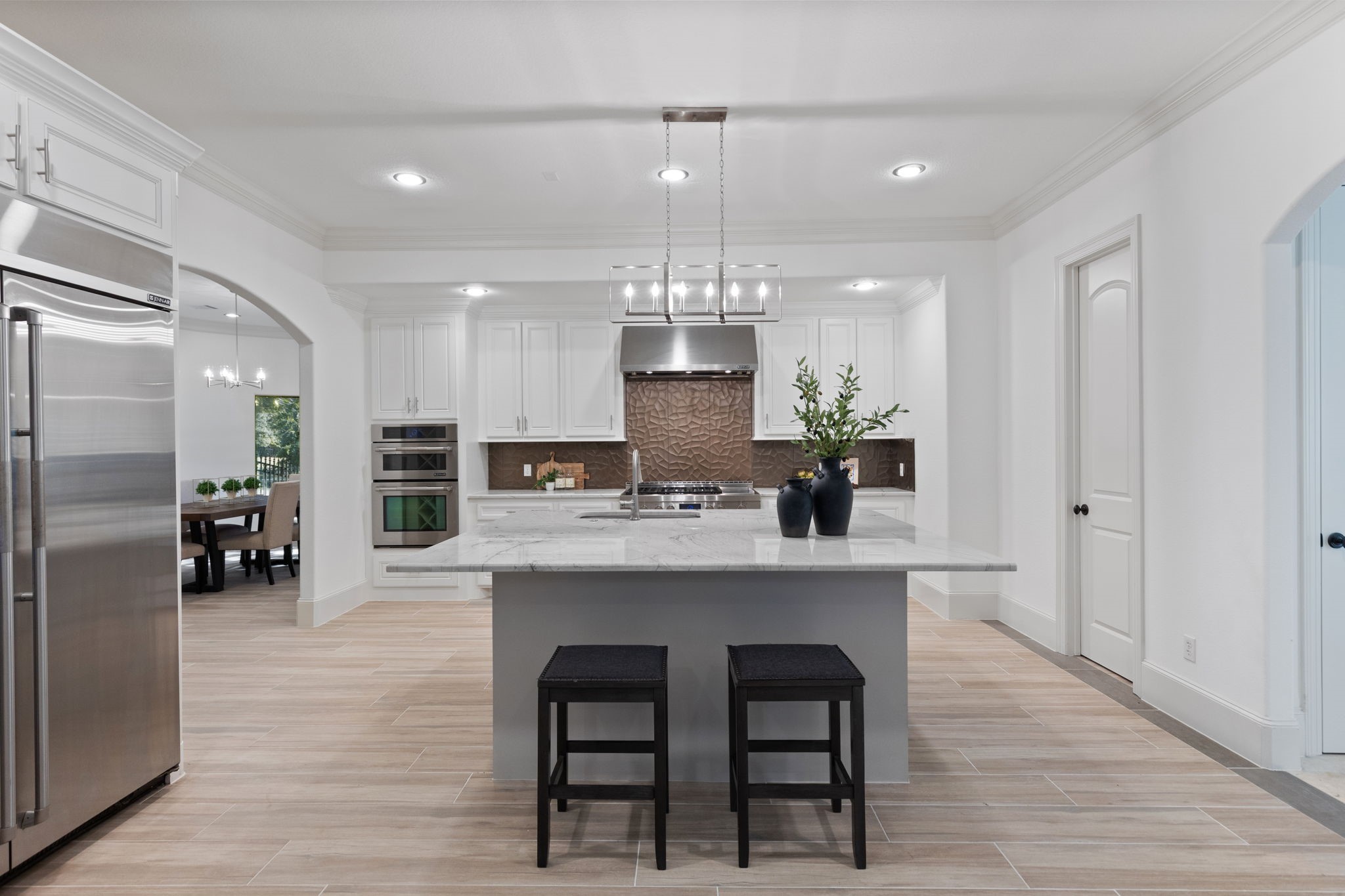27502 Whispering Maple Way Spring, TX 77386 - Photo 11 of 46 a kitchen with stainless steel appliances a dining table chairs and wooden floor