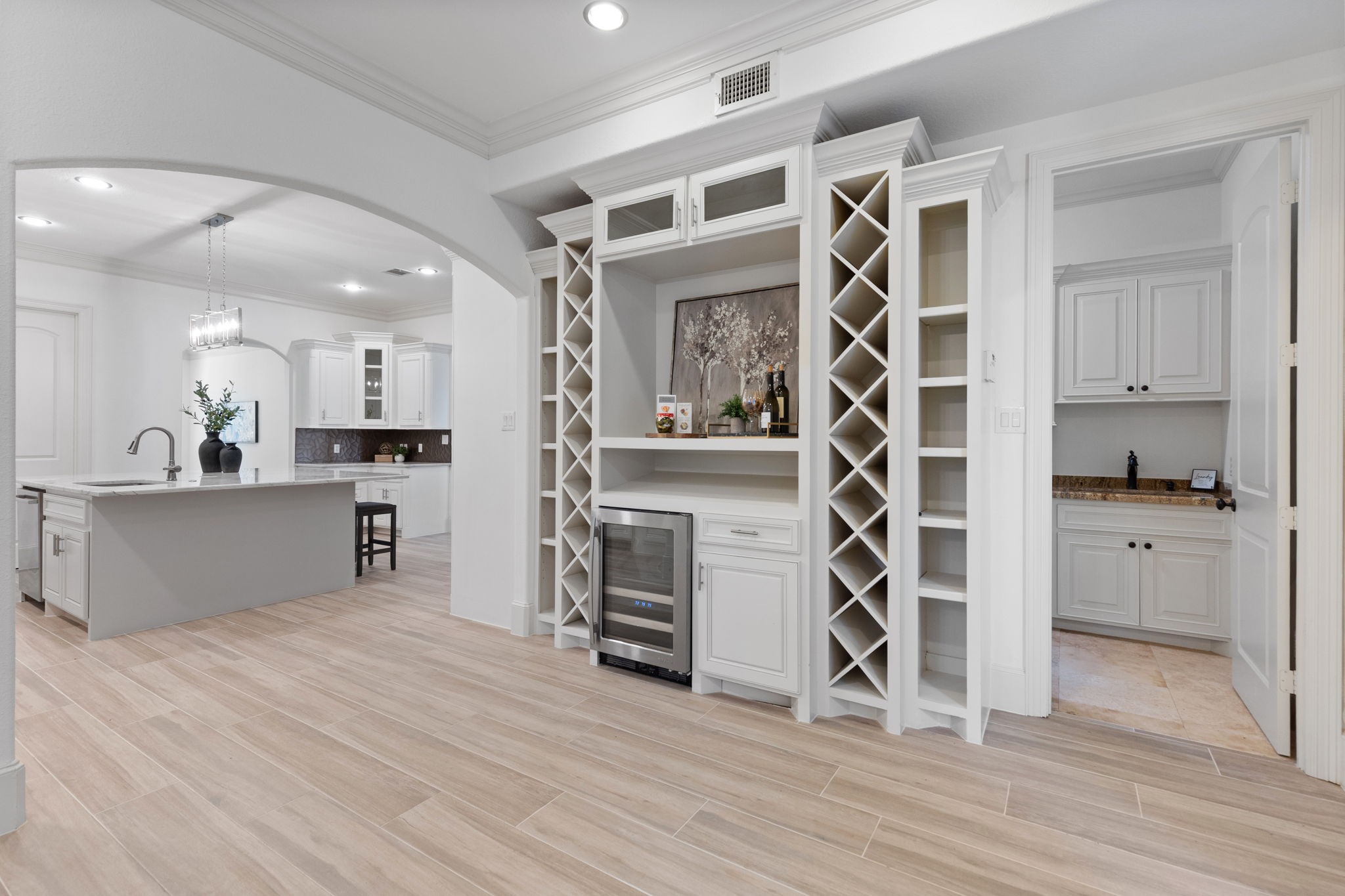 27502 Whispering Maple Way Spring, TX 77386 - Photo 15 of 46 Perfectly situated off the Kitchen, this Wine Bar/Butler’s Pantry offers abundant wine storage, a JennAir wine fridge, crown molding, and French doors leading to the garage breezeway.
