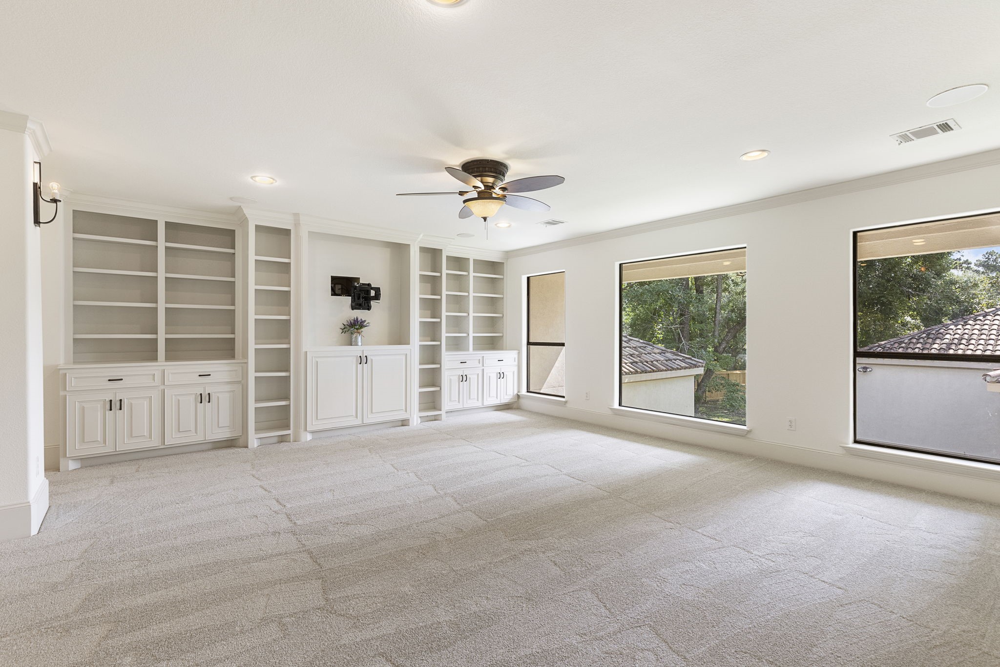 27502 Whispering Maple Way Spring, TX 77386 - Photo 30 of 46 Expansive Game Room featuring a full wall of built-ins for storage, massive windows filling the space with natural light, crown molding, new carpet, and built-in ceiling speakers.