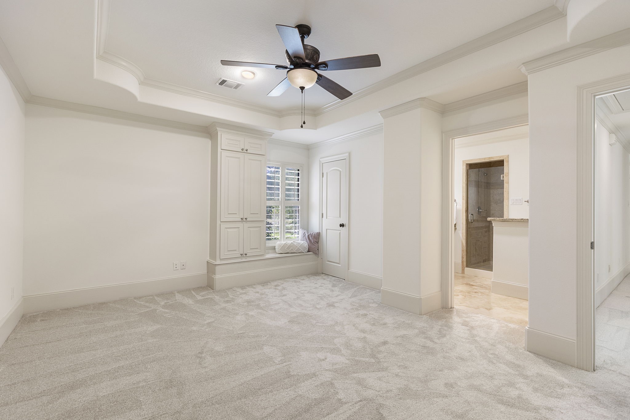 27502 Whispering Maple Way Spring, TX 77386 - Photo 33 of 46 Another large Secondary Bedroom with new carpet, window bench seating with built-in storage, tray ceiling with crown molding, ceiling fan, and walk-in closet with built-ins.