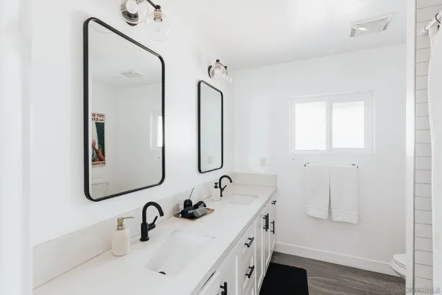a bathroom with a double vanity sink mirror double and shower
