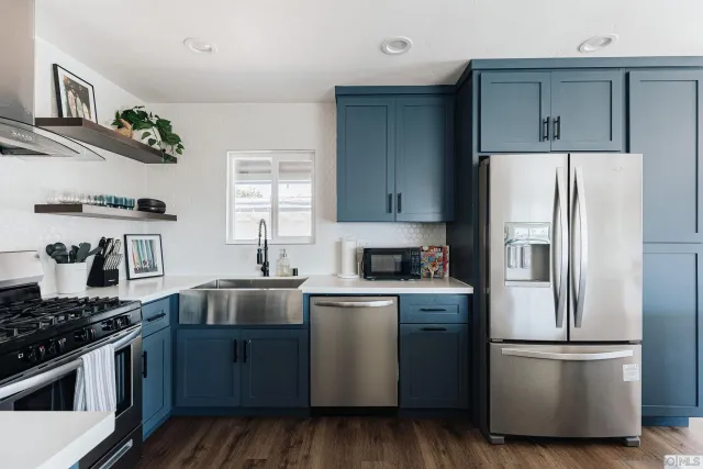 a kitchen with stainless steel appliances a table chairs and refrigerator