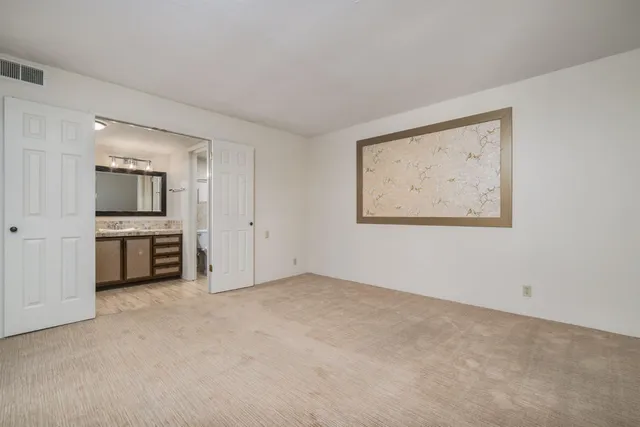 a view of an empty room with closet and a window