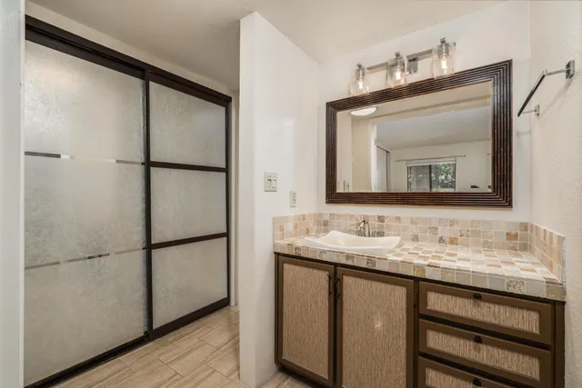 a bathroom with a granite countertop sink toilet and shower