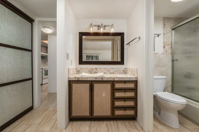 a white toilet sitting next to a bath tub and a shower