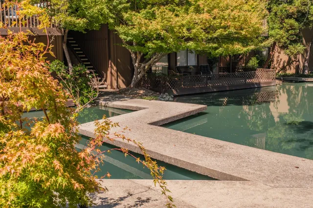 a view of patio with chairs and a table under an umbrella