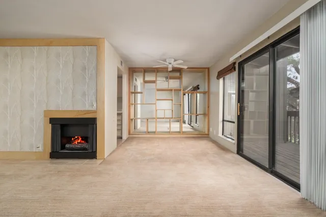 an empty room with cabinet and windows