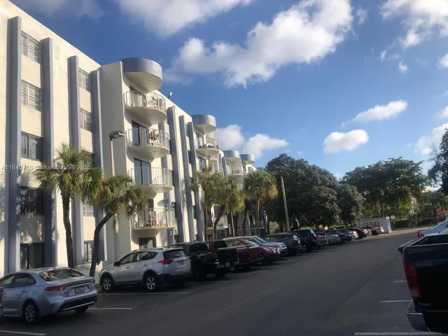 a city street lined with parked cars and buildings