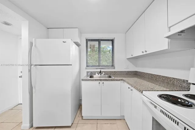 a kitchen with a sink a refrigerator and cabinets