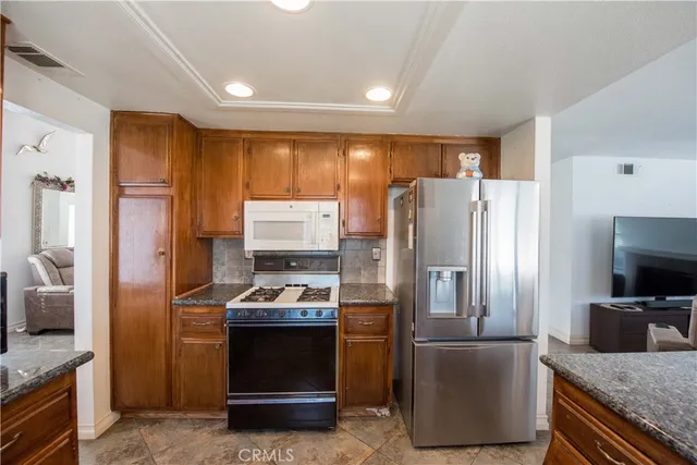 a kitchen with stainless steel appliances granite countertop a refrigerator and a stove