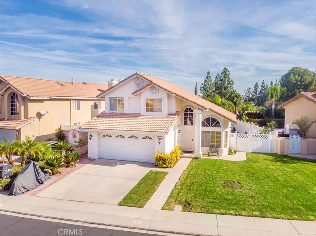 a front view of a house with a yard and potted plants