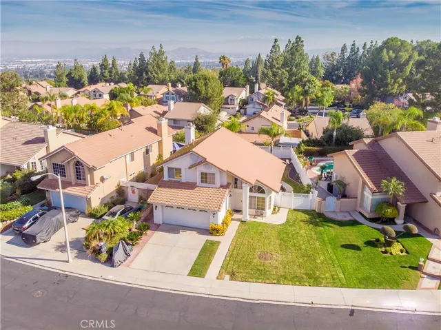 an aerial view of a house with a garden and mountain view