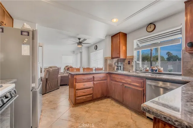 a large kitchen with stainless steel appliances a stove a sink dishwasher and cabinets