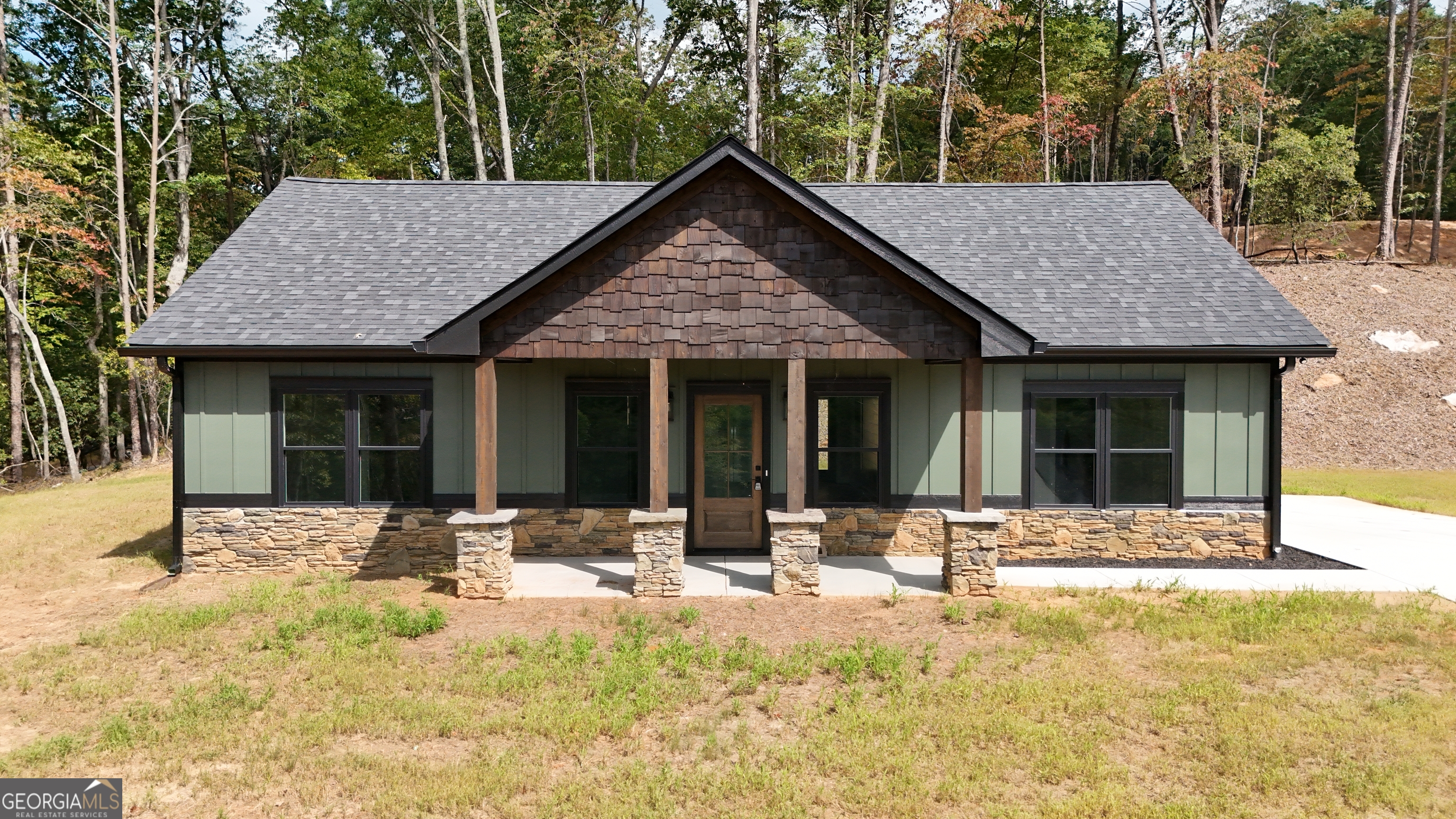 a front view of a house with a yard outdoor seating and yard in the back