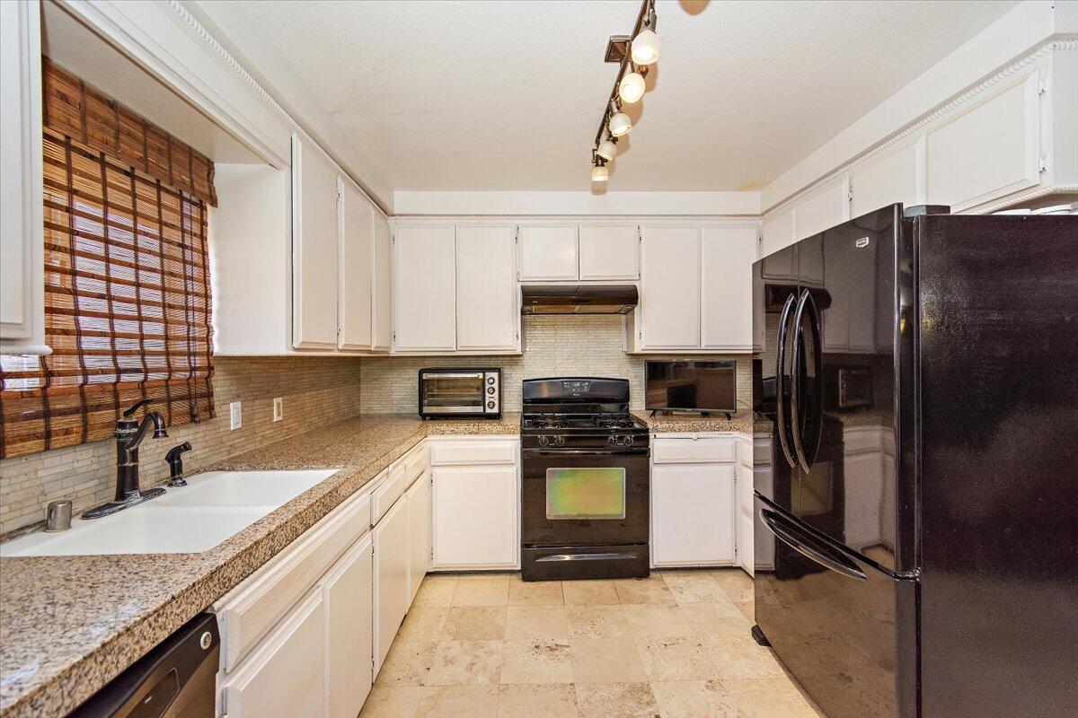 51884 Ida Avenue Cabazon, CA 92230 - Photo 5 of 25 a kitchen with a refrigerator a sink and cabinets