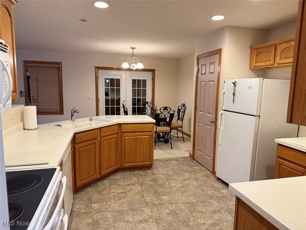 3718 Babcock Road Williamsfield, OH 44093 - Photo 19 of 31 Kitchen featuring sink, a chandelier, hanging light fixtures, white appliances, and french doors