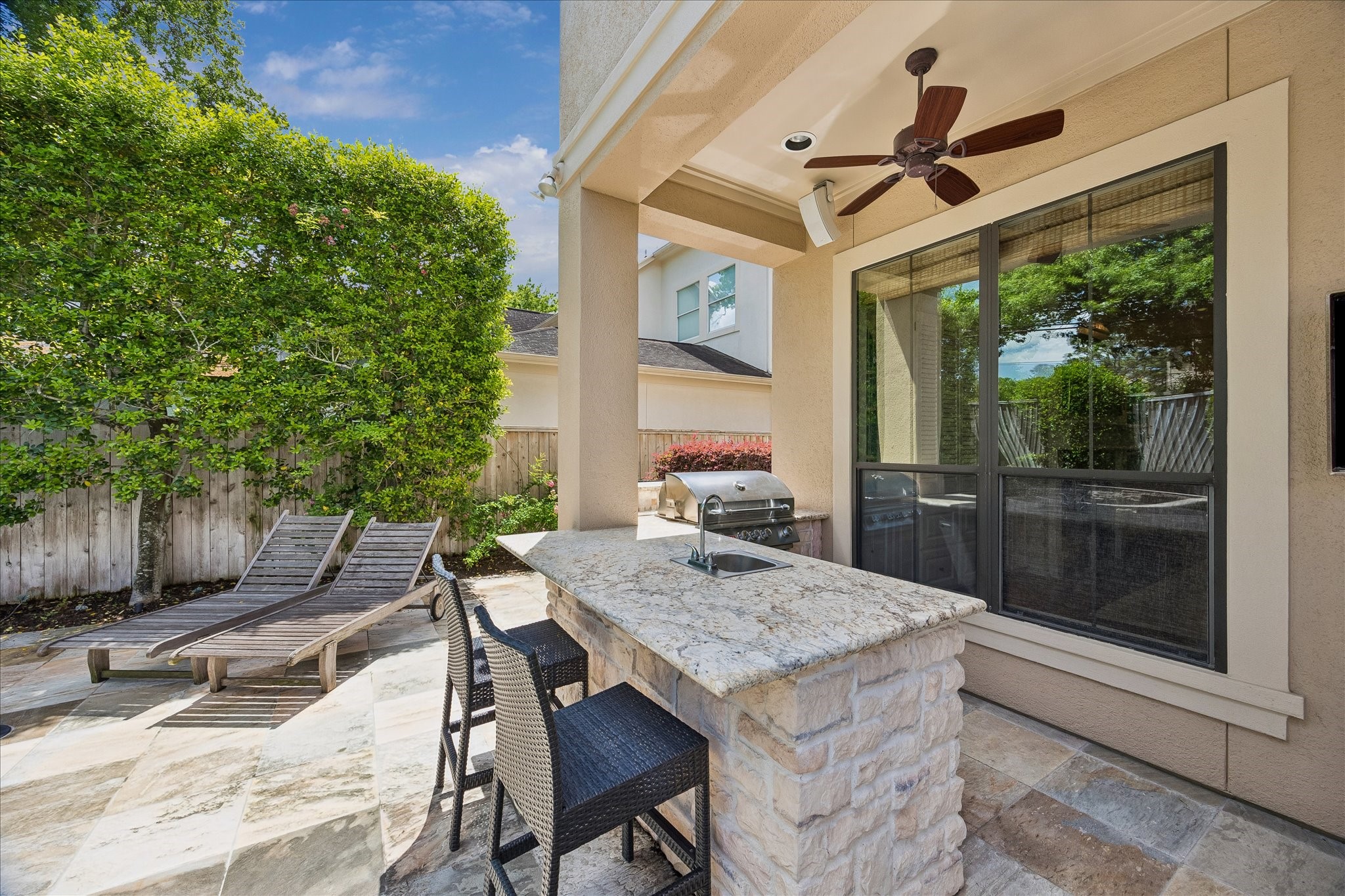 802 Anderson Street Bellaire, TX 77401 - Photo 29 of 36 This fully equipped summer kitchen has a sink, refrigerator, new ice maker, built in grill, a ceiling fan, and a television.