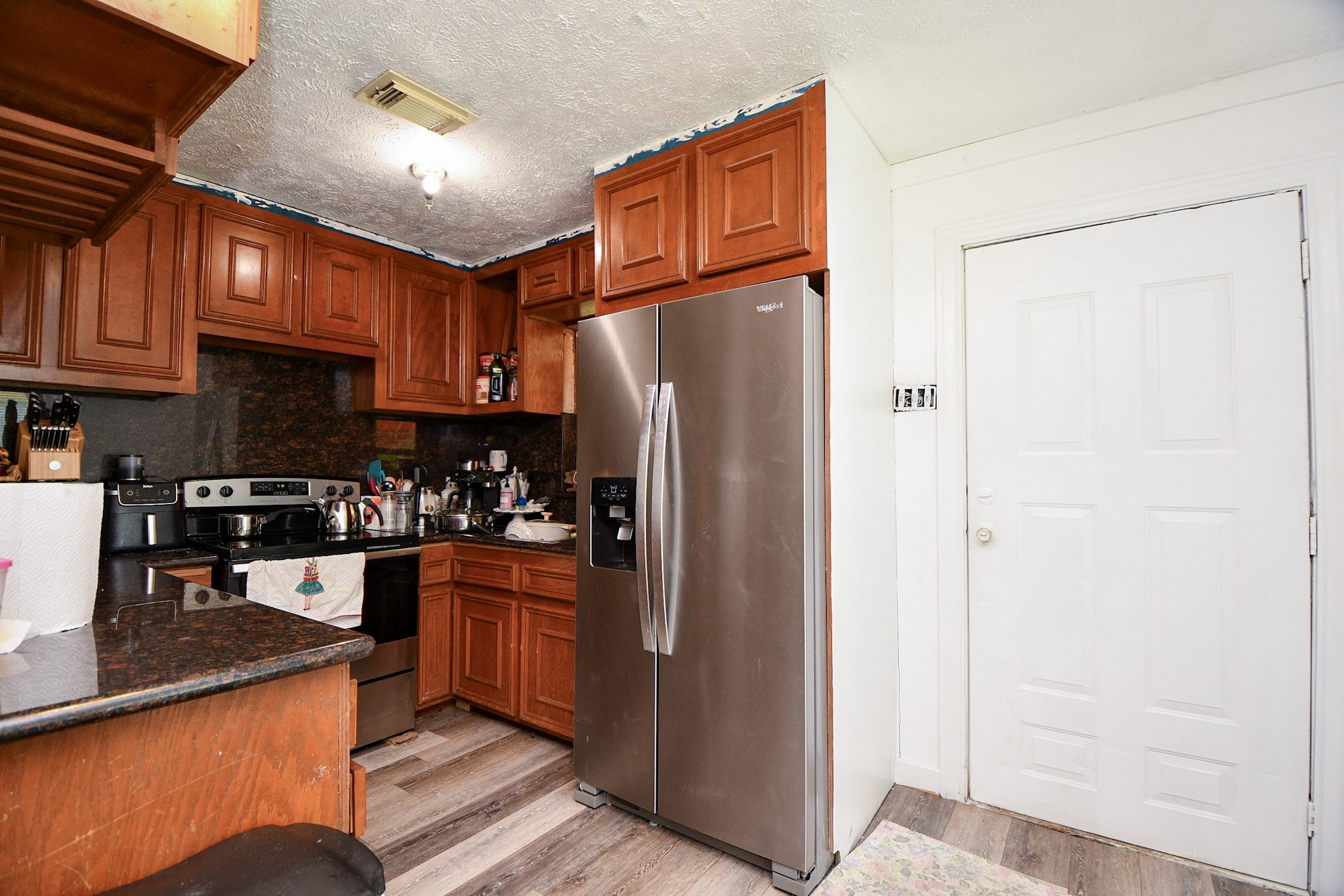 16005 Old Richmond Road Sugar Land, TX 77498 - Photo 27 of 46 a kitchen with stainless steel appliances granite countertop a refrigerator a stove and a sink with wooden floor