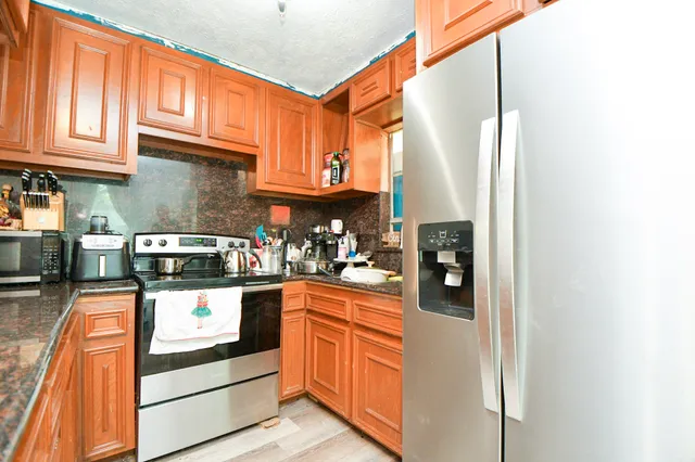 a kitchen with stainless steel appliances granite countertop a refrigerator and a stove