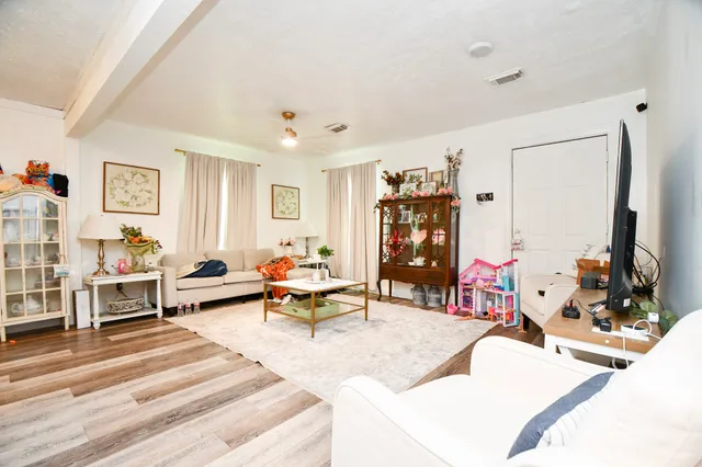 a living room with furniture and wooden floor