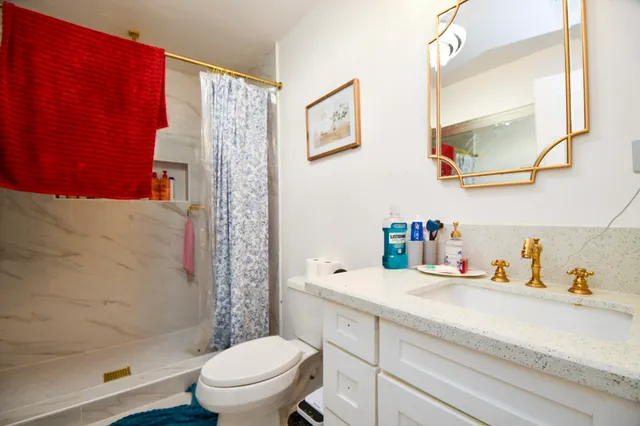 a bathroom with a sink a toilet and shower curtain